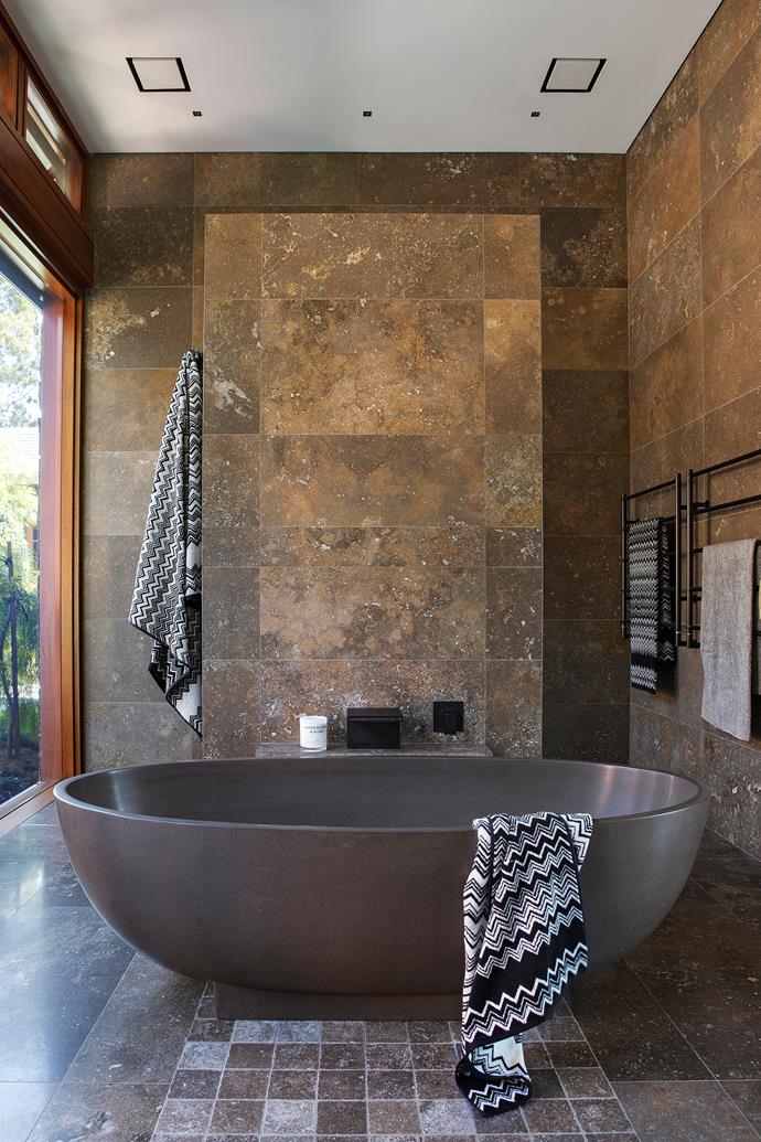 **Lie back and relax.** Whilst the mink-toned freestanding bath, marble shower screen wall and Missoni towels are all impressive, it's the floor-to-ceiling window and verdant view that really make this bathroom a game-changer. *Photo: Prue Ruscoe / bauersyndication.com.au*
