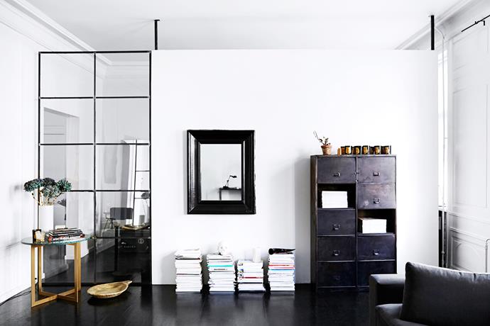 A steel-framed gridded window wall was installed to partition off the living room from the dressing room, while still allowing light to flow through. Mirrors, too, help to bounce light around the space.