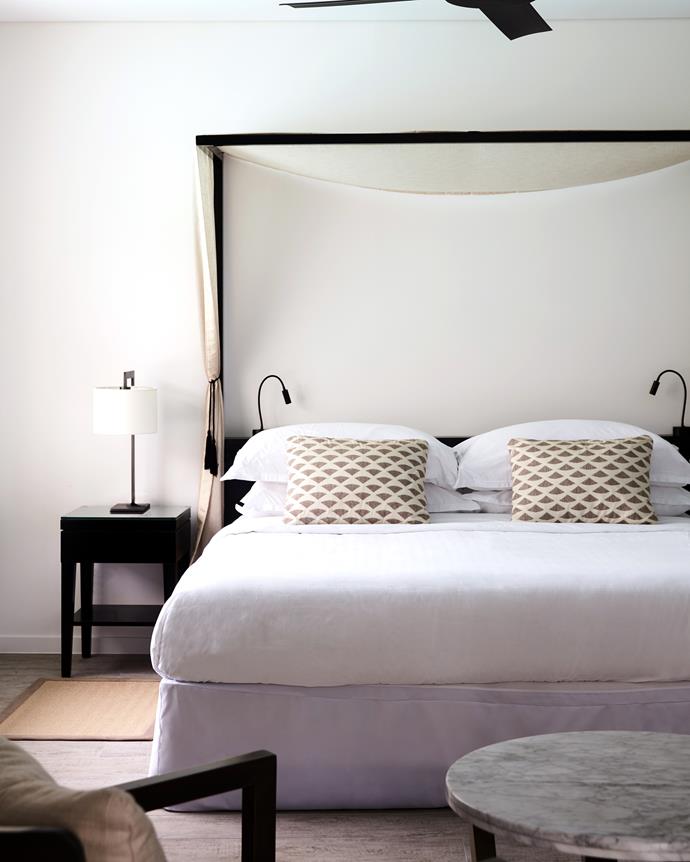 The guest bedrooms adopt a more minimal aesthetic, with crisp muted textiles and breezy canopied beds. With the addition of driftwood timber-tiled floors and natural wood furnishings, it’s contemporary coastal chic at its finest.