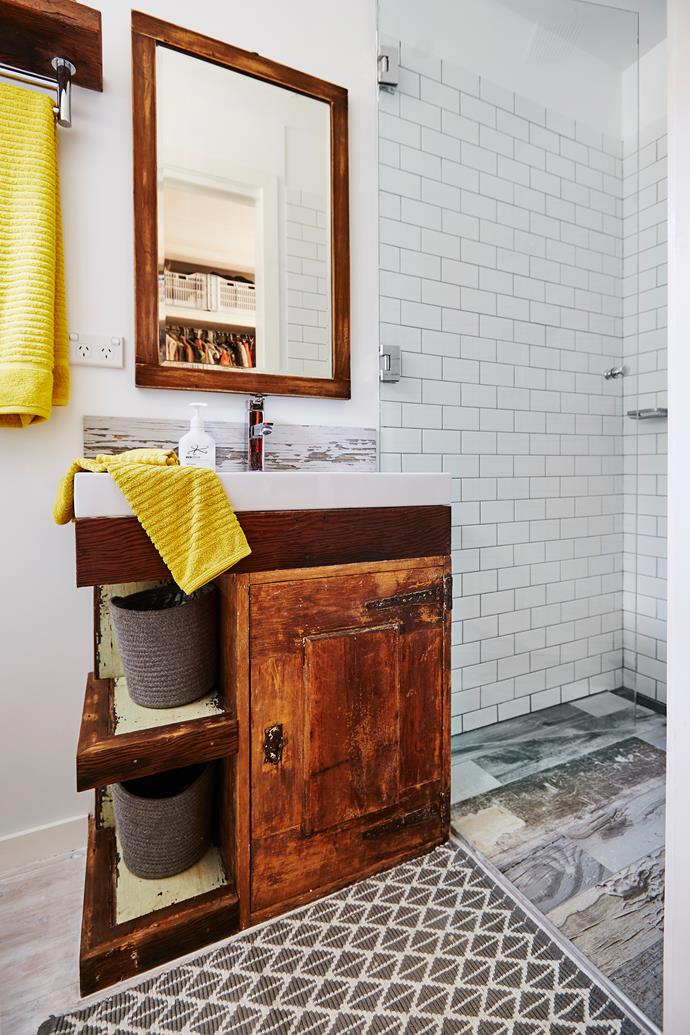 The DIY projects continue in the bathroom, where Scott transformed an old ice box (picked up for just $20) into a vanity by adding on a sink, removing the interior shelves and building a few new ones out of recycled timber on the side.