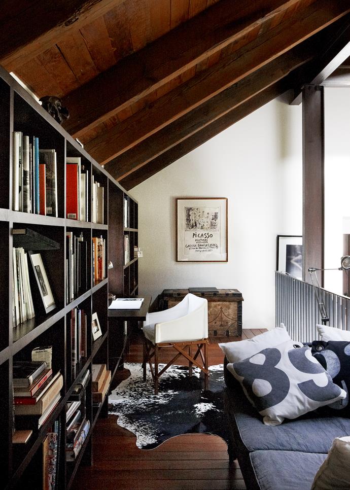 In the library, russet wood tones in flooring and vaulted wooden ceiling are the essence of country style in an urban setting. The mix of vintage and modern pieces is just right.