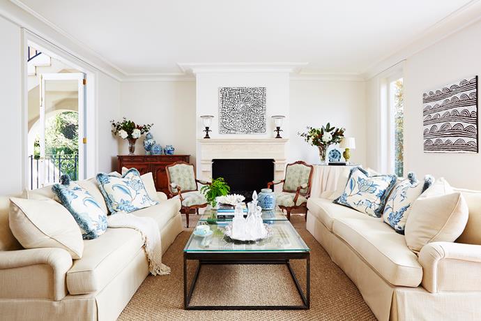 This provincial-style sitting room was curated around the new fireplace and honed-travertine mantel by Richard Ellis Design. Sofas custom-designed by Lynda Kerry with Jane Churchill fabric. Artwork by Nyurapayia Nampitjinpa, through Susan Manford Contemporary Art.