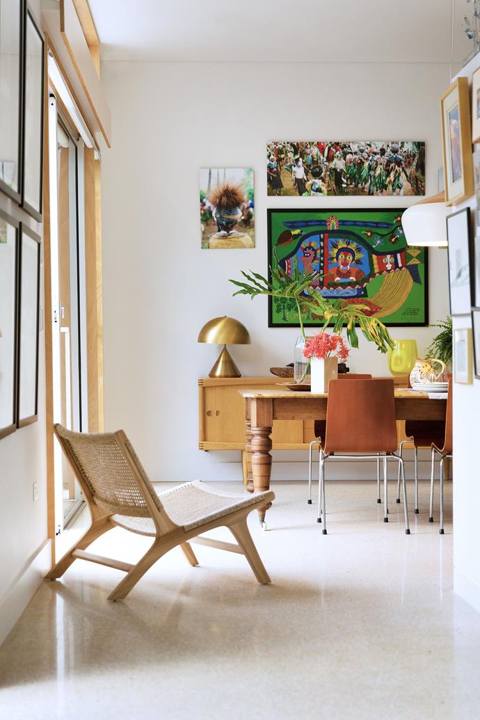 Above the sideboard hangs a Mathias Kauag painting and photographs by John