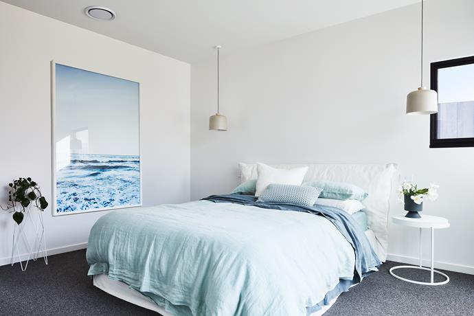 In one of the bedrooms, an ocean-inspired artwork and bedlinen in watery hues echo the coastal
location of the home.