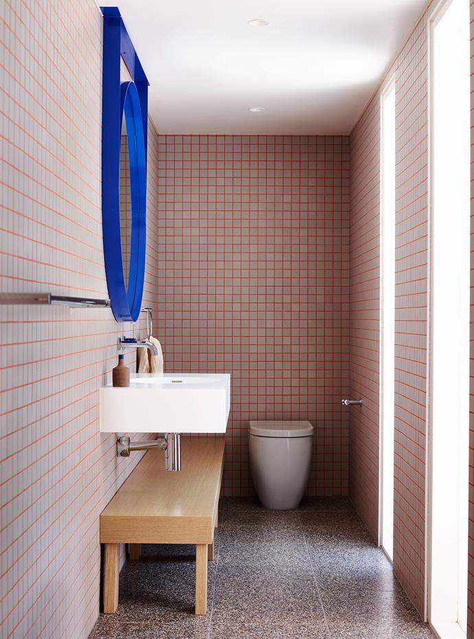 Warm pink grout syncs with a snazzy blue custom mirror to round off a punchy aesthetic in this bold bathroom by [Doherty Design Studio](https://www.dohertydesignstudio.com.au/|target="_blank"|rel="nofollow"). “Our approach was to bring a fun, graphic aesthetic to what is a narrow space. The bespoke large round mirror in blue is a feature and sits on top of the checkerboard patterned tiled wall that adds a punchy playful element to the room. The pink grout used for the tiles is a favourite design feature and helps to accentuate the length of the narrow room,” says designer Mardi Doherty. *Photo: Mark Roper*
