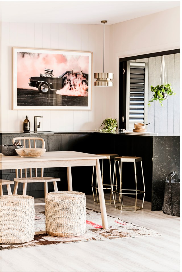 With such a small space to work with, Three Birds Renovations had this chic kitchen in their [river shack renovation](https://www.homestolove.com.au/three-birds-caravan-and-river-shack-renovation-5565|target="_blank") custom made by [Carrera by Design](https://www.carrera.com.au/|target="_blank"|rel="nofollow"). It features a Caesarstone benchtop in Vanilla Noir and Luxaflex aluminium shutters. The artwork by Simon Davidson ties the dramatic colour palette together.