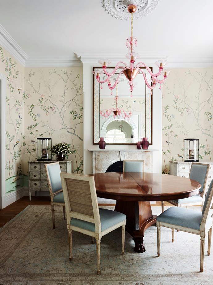 The formal dining room has a custom-made table in American walnut veneer with oiled finish. Dessin Fournir 'Lena' chairs from Kneedler Fauchère LA. Murano glass chandelier. French mid-century mirror from Conley & Co. Custom de Gournay wallpaper panels from Milgate.