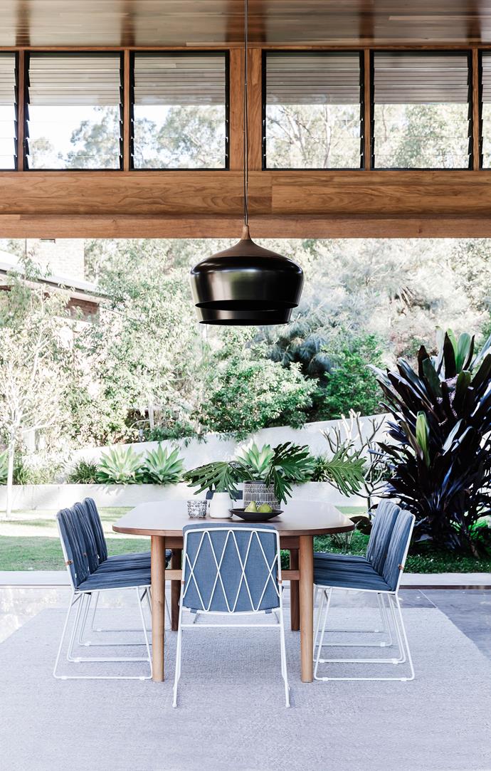 Sliding doors retract completely on both sides of the space to create the feeling of an outdoor room. Custom-made dining table.'Seb' dining chairs, from Jardan. Coco Flip 'Coco' pendants, from Cult. Rug, Armadillo & Co.
