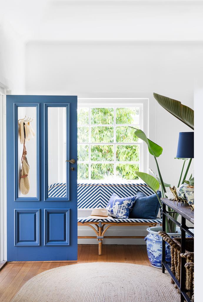 Glazed door panels give visitors a glimpse of the home's breezy decor. Once inside, a woven bench from Lincoln Brooks gives an impression of deep ease.