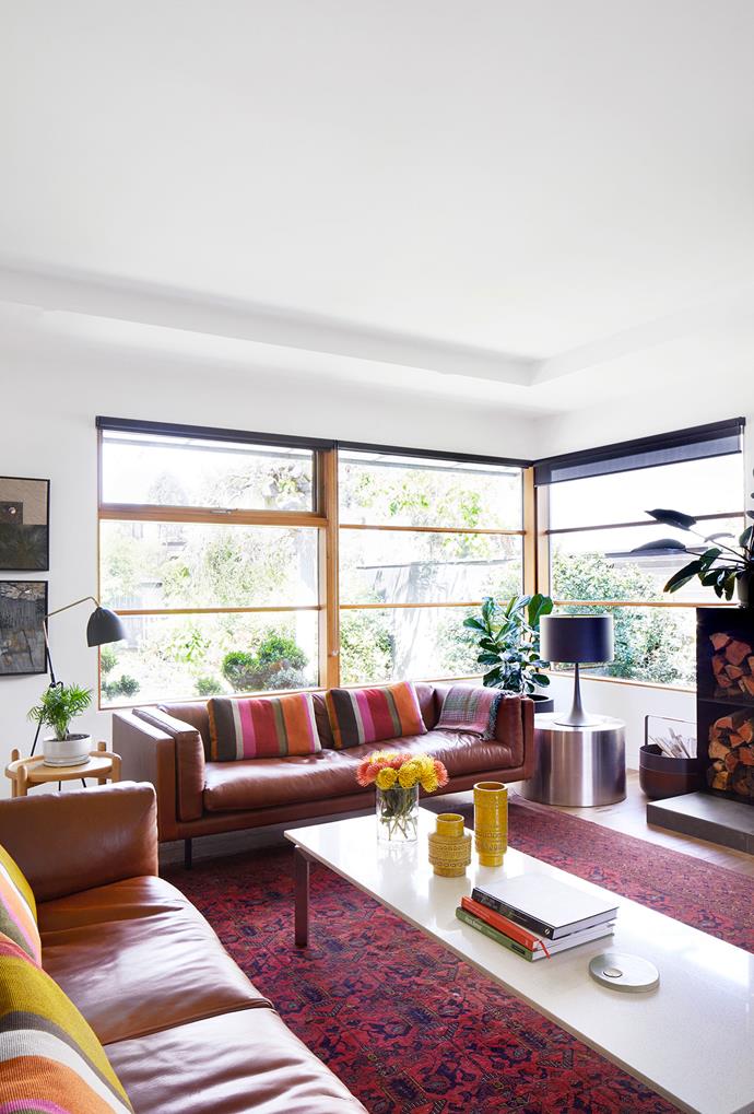 Generous windows ensure the beautifully landscaped front garden becomes a feature of the living room too. 'Harvey' sofas, Grazia & Co. 'Lean' floor lamp, Great Dane (left). Flos 'Spun Light T1' table lamp, Euroluce. Sheer roller blinds, Inside Edge. Rug, Saffar's Fine Rug Collection. Artworks by Fiona Austin.