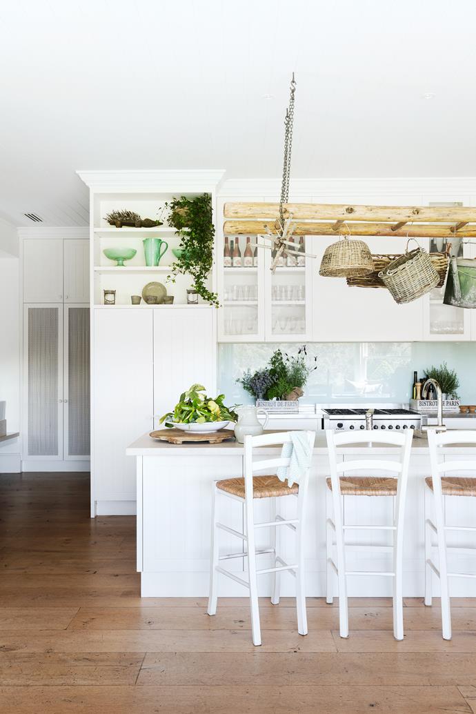 "This is such a warm and welcoming room," says designer Adelaide Bragg. "With checked curtains, natural linens, hanging baskets and a dresser filled with china and trinkets, it epitomises a country kitchen." Benchtop, Caesarstone Buttermilk.