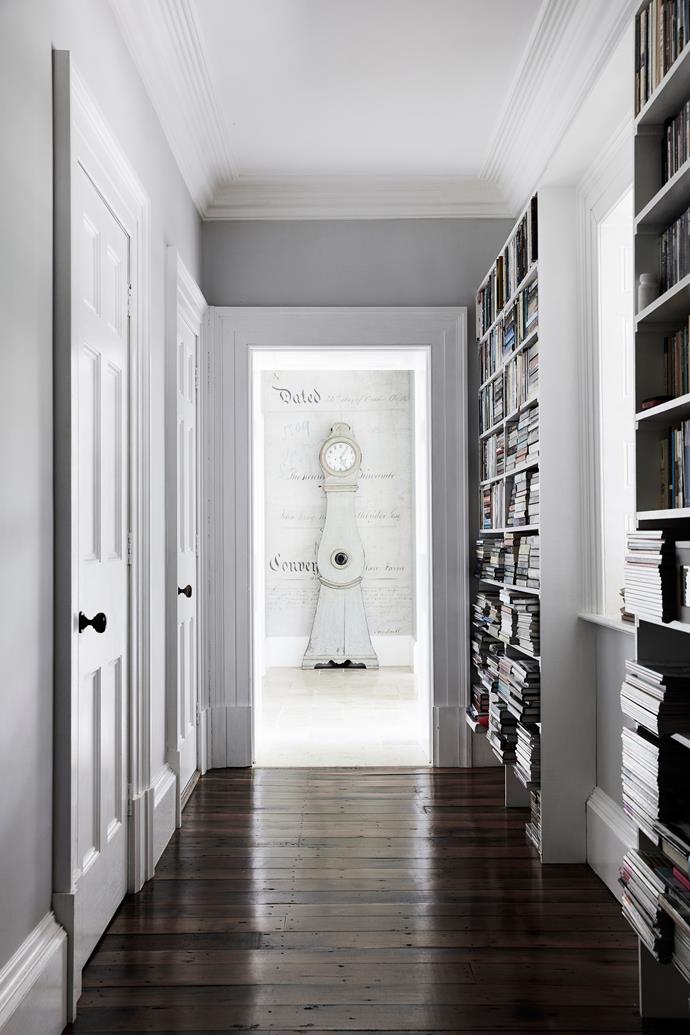 The home's small existing kitchen was transformed into a corridor between the main living areas and new orangery. A powder room and laundry are concealed behind doors on one side, while bookshelves line the facing wall.