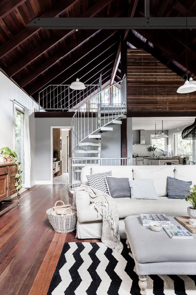 The staircase connects this main level with the main loft bedroom above and children's rooms below. Plush, soft textiles make a comfy counterpoint to durable timber and steel.