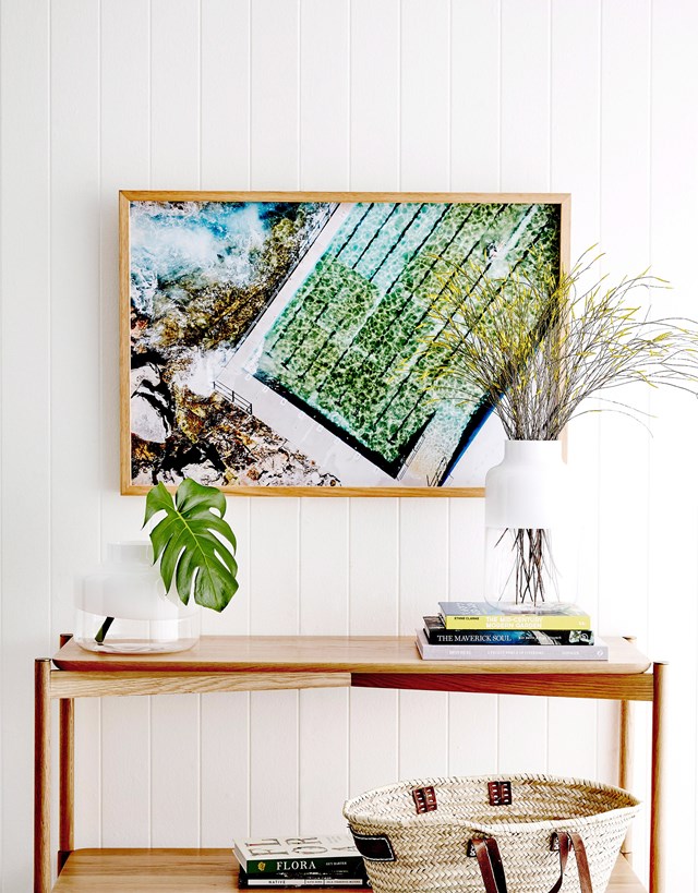 Blues, greens and natural tones in this artwork are complemented by timber furniture pieces and fresh greenery. *Photo:* Will Horner / bauersyndication.com.au