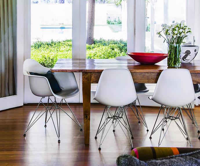 White Eames chairs surrounding a timber dining table