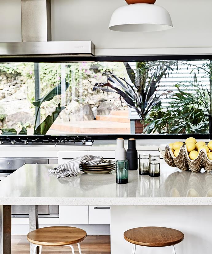 Rather than obstructing the views, a five-metre window doubles as a splashback in the kitchen.