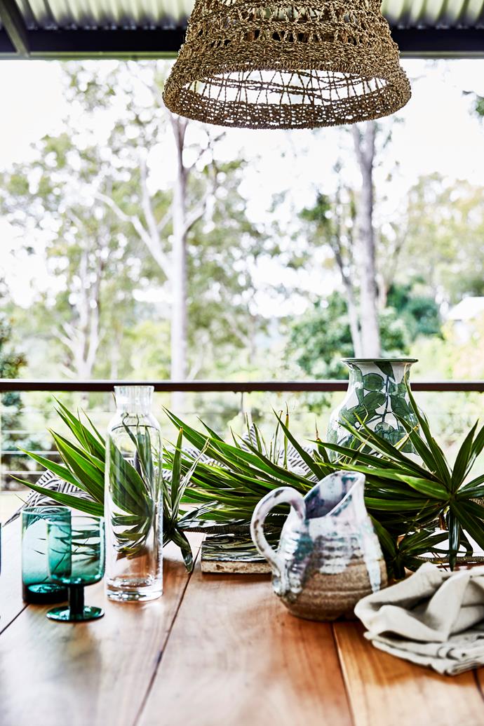 The custom-made outdoor dining table displays some of Lauren's treasured pieces, including a tile bought at a Sicilian flea market, carafe by Normann Copenhagen and a vase made by a friend.