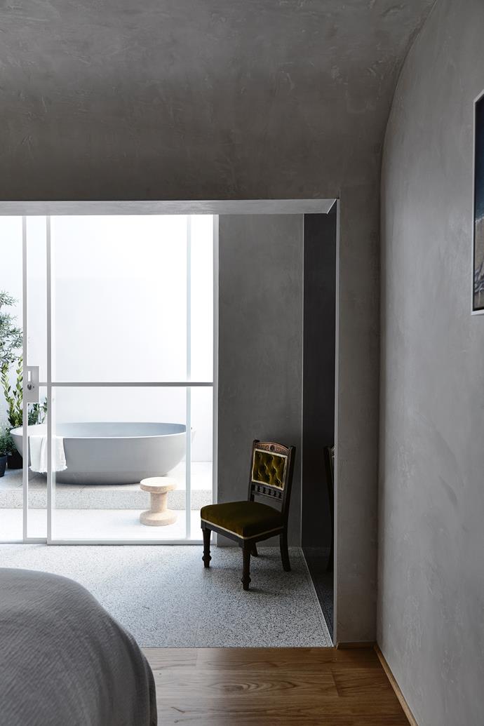 The cavernous master bedroom in a [renovated Church in Hawthorn](https://www.homestolove.com.au/renovated-church-in-melbourne-6912|target="_blank") opens out onto a private courtyard bathroom. It's a bold design that works with the home's layout, serving the dual purpose of allowing light to spill down from above.