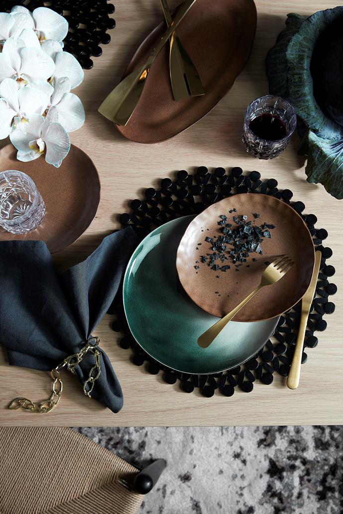 Rustic styles of dinnerware in bold hues are on-trend this season. This dining table features 'Anya' black round bamboo **placemats**, $14.95, 'Bond piano' glass **tumblers**, $39.95, and 'Selene' side plate, $87, all from [Temple & Webster](https://fave.co/2O6Ky3v|target="_blank"|rel="nofollow"). *Photo: Temple & Webster*