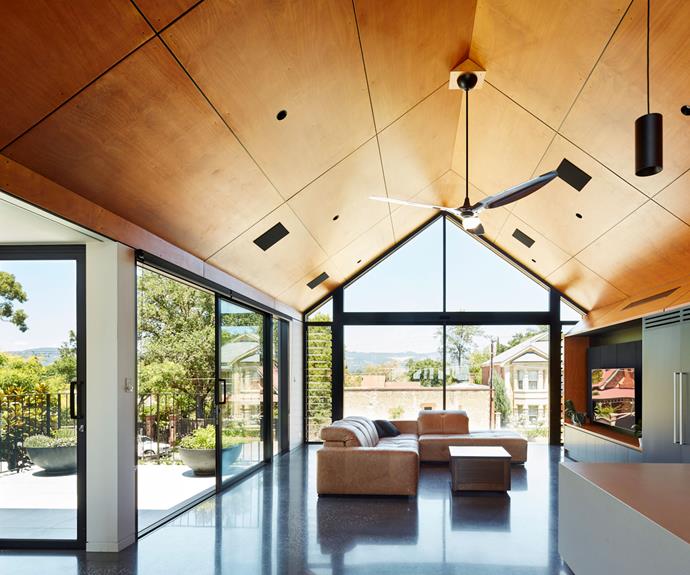 A black polished concrete floor maximises heat retention from the winter sun. Golden-toned plywood ceilings make the space feel light (which is important to balance the dark floor).