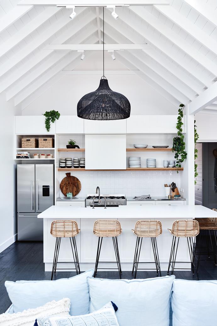 A relaxed, casual vibe permeates holiday home [Soul of Gerringong on the NSW South Coast](https://www.homestolove.com.au/coastal-farmhouse-reno-gerringong-18827|target="_blank"). The home, which is styled according to a coastal farmhouse aesthetic features rattan bar stool, a woven pendant light and a cathedral ceiling. "The big open-plan kitchen/lounge/dining space is where the outside kitchen once was," explains former owner Simone. "We've made that the hub of the home to pay homage to how it would have been back in the 1800s.