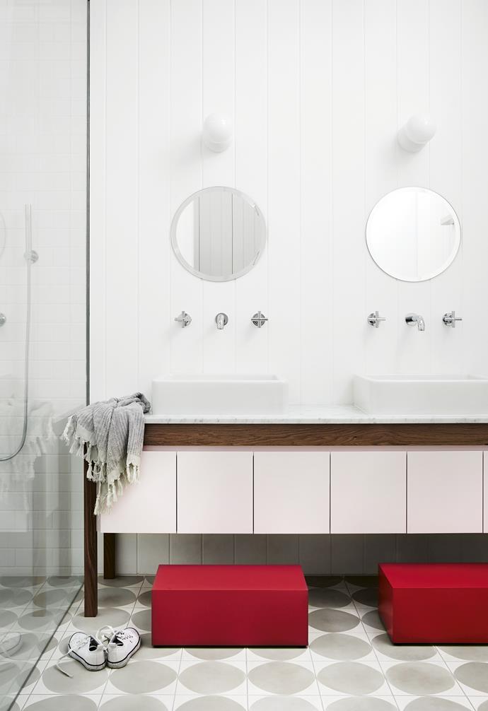 **Step up**<br>
Designed with daughters in mind, the soft pink cabinetry is played up by the red footstools. The statement grey flooring ensures that the space is still on-point as the girls get older and no longer need the stools.