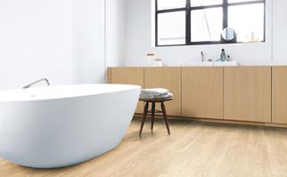 Freestanding bath tub in a bathroom with timber look floors