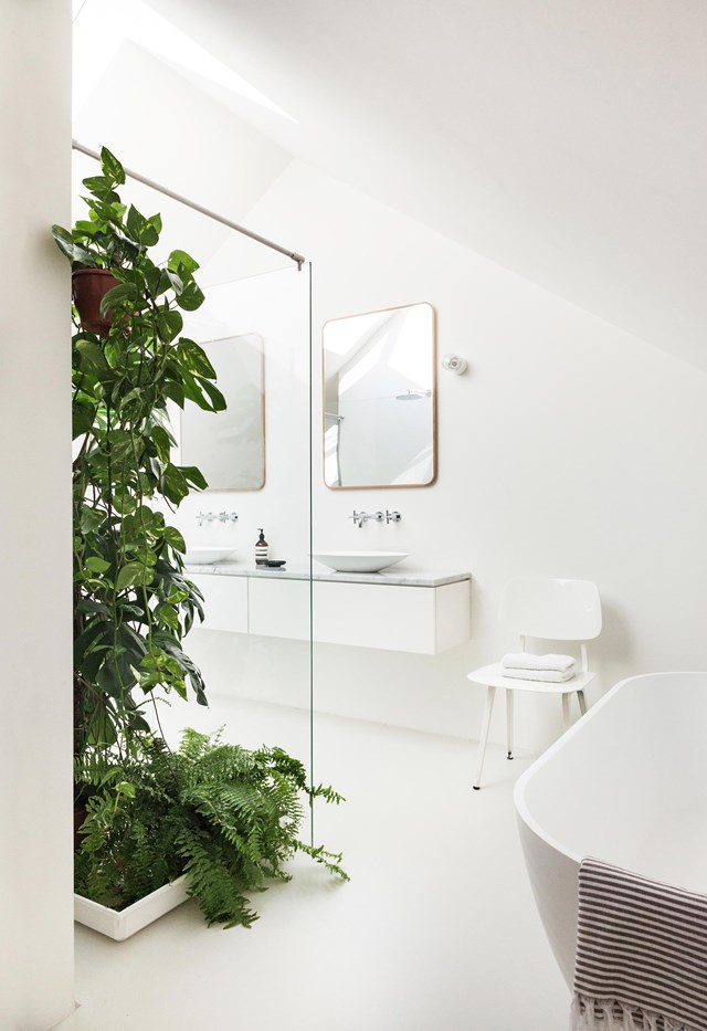 Rays of sunshine streaming in through a pair of skylights are magnified by an all-white palette in this bathroom. The only colour comes from a [cascading indoor plant] and a cluster of lush ferns. This [eco-friendly pre-fab home](https://www.homestolove.com.au/prefab-eco-friendly-home-19148|target="_blank") was built within an experimental sustainable neighbourhood in the Netherlands.
