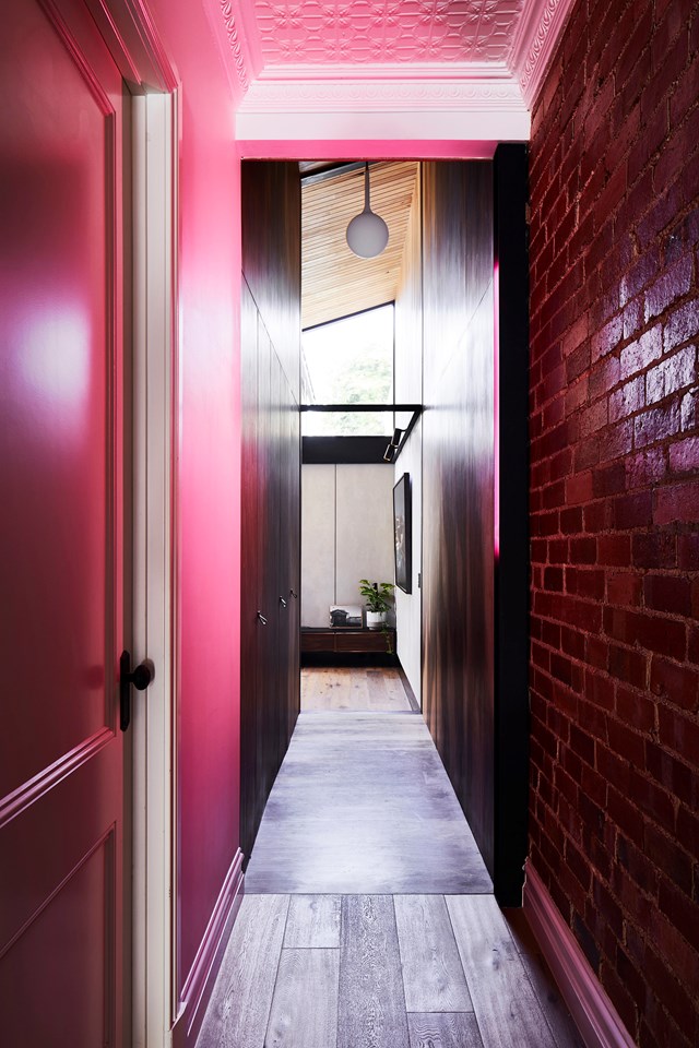 Don't be fooled by the ultra-modern hues in this hallway. Look closer and you'll find plenty of original detailing hiding in plain sight: the pressed tin ceiling and exposed brickwork. Built as a [workers' cottage](https://www.homestolove.com.au/a-renovated-workers-cottage-that-maximises-space-19157|target="_blank") in 1912, this home has been renovated and expanded for a growing family.