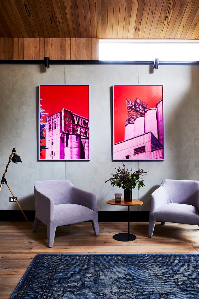 These artworks by Kate Ballis are a colourful feature on the cool grey fibre-cement wall. The steel railings can be read as a witty reference to traditional picture rails. 'Kelly' armchairs, from Jardan.