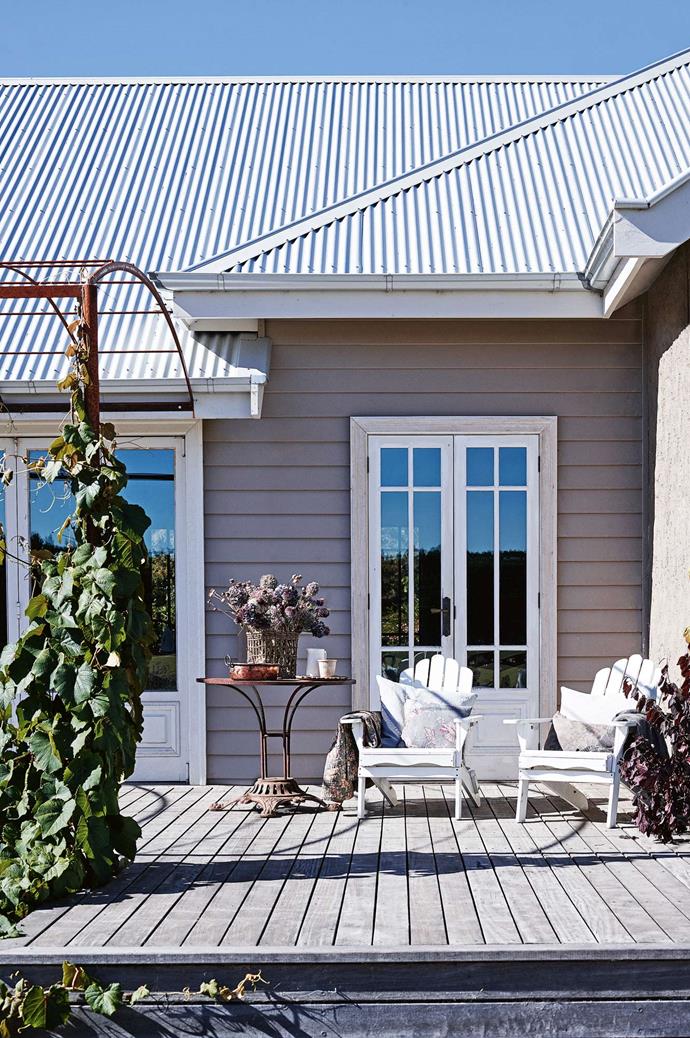 The deck of this [family farmhouse in the Macedon Ranges](https://www.homestolove.com.au/share-house-a-family-farmhouse-in-the-macedon-ranges-14014|target="_blank") overlooks the surrounding gardens and paddocks. The arbour was handmade for the crimson glory vine. | *Photography: Mark Roper*