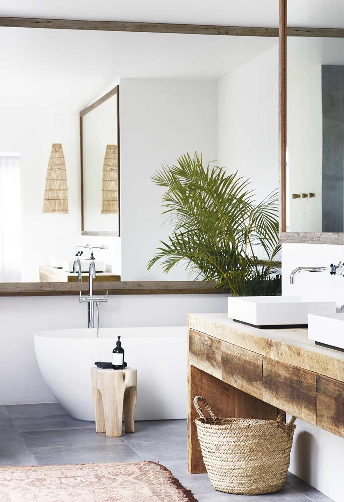 The white-whites of this rendered [Byron Bay bathroom](https://www.homestolove.com.au/relaxed-all-white-byron-bay-home-with-upcycled-details-19266|target="_blank") are punctuated by warmth via timber and rattan accents, a potted palm and near-wall-sized framed mirrors, all of which also serve to accentuate the home's coastal location.