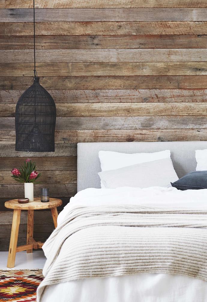 **Main bedroom** A bedhead made by Emma works together with the timber wall, stool, black pendant and [Tigmi Trading](https://tigmitrading.com/|target="_blank"|rel="nofollow") rug to create a cosy space. Upcycled timber detailing throughout the all-white interior ensures that the home is not sterile or stark and is in keeping with the couple's commitment to sustainable living. Bedroom stool, [Island Luxe](https://www.instagram.com/islandluxeofficial/?hl=en|target="_blank"|rel="nofollow"). Pendant, [Ha'veli of Byron Bay](http://www.haveliofbyronbay.com.au/|target="_blank"|rel="nofollow").