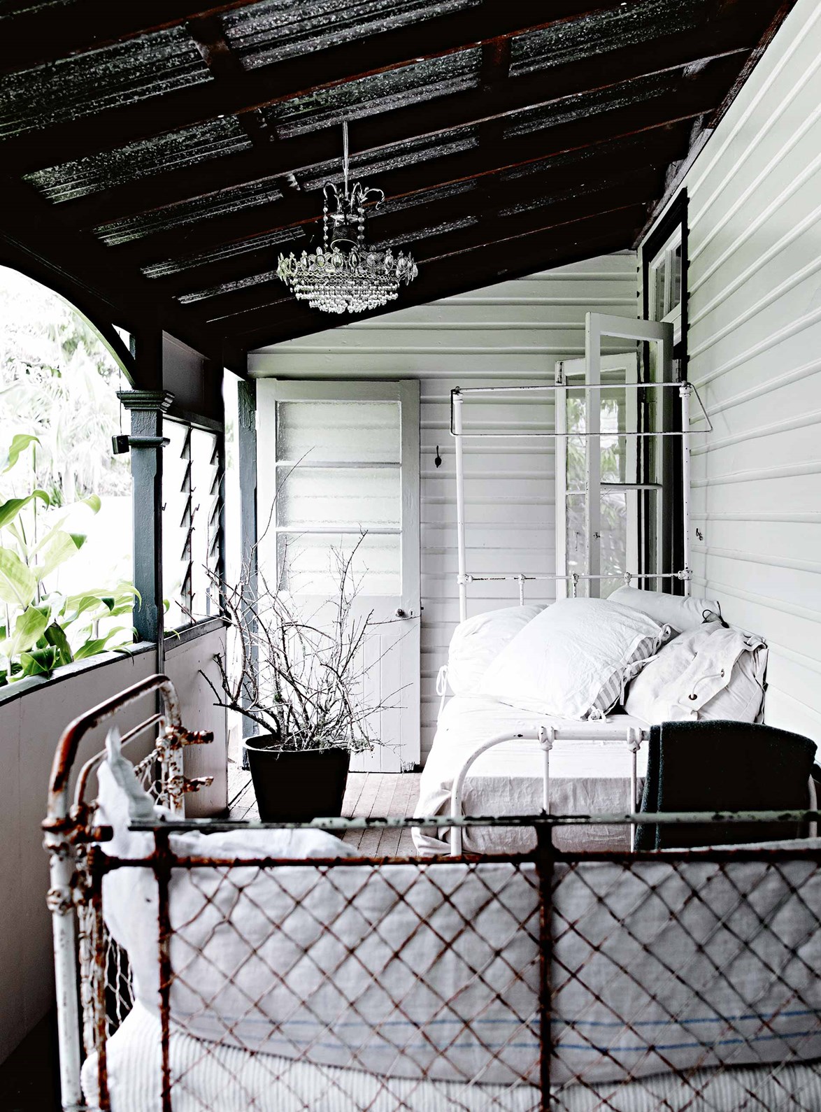 Comfy vintage daybeds and a sparkling chandelier have transformed an old verandah into a shabby chic retreat. That's because the verandah is where [Byron Bay homeowner and dressmaker](https://www.homestolove.com.au/dressmakers-white-vintage-interior-in-the-byron-bay-hinterland-13719|target="_blank") Michelle Douglas does the majority of her work, designing and sewing clothing for her two labels [Meg By Design](https://megbydesign.com/|target="_blank"|rel="nofollow") and [Chapel & Co](https://chapelandco.com/|target="_blank"|rel="nofollow").