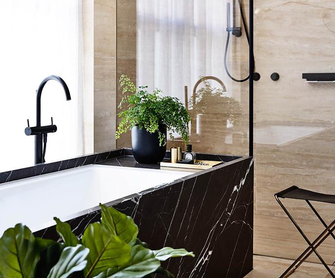 Black marble inset bath tub with indoor plants