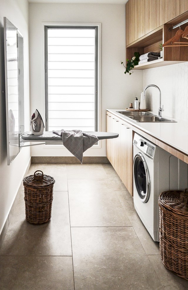 This cleverly designed laundry features a wall-mounted ironing board cupboard to maximise space.