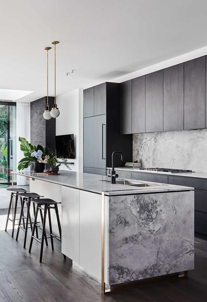 **Colour contrast** Dark cabinetry in the kitchen makes the light marbled stone on the [island bench](https://www.homestolove.com.au/kitchen-inspiration-13-of-the-best-island-benches-17943|target="_blank") and [splashback sing](https://www.homestolove.com.au/12-splashback-ideas-that-arent-white-subway-tiles-17258|target="_blank"). Twin pendants add a modern luxe touch with brass highlights echoing in the space.