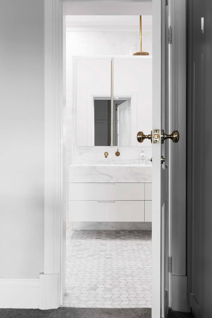 The bathroom has chevron marble floor tiles in Ice Snow from [Italia Ceramics](https://italiaceramics.com.au/|target="_blank"|rel="nofollow"). Brass tapware and finishes add the the space's timeless aesthetic.