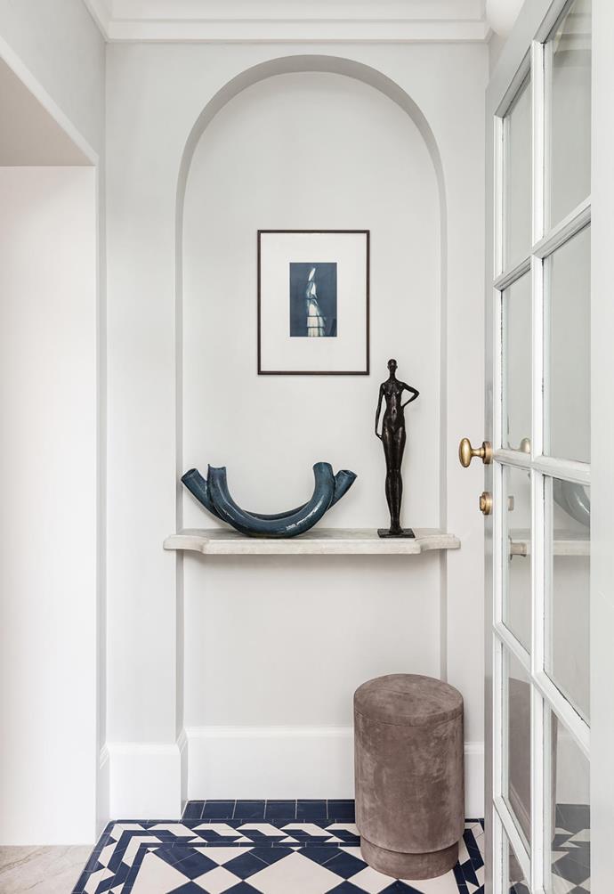 In the entry is a ceramic sculpture by Susie Solomon from Graphis Art + Framing and 'Sasha' by Corbin Bronze sculpture from Studio Cavit. Artwork by Laura Ellenberger. 'Tabou' pouf by Michael Verheyden from Ondene.