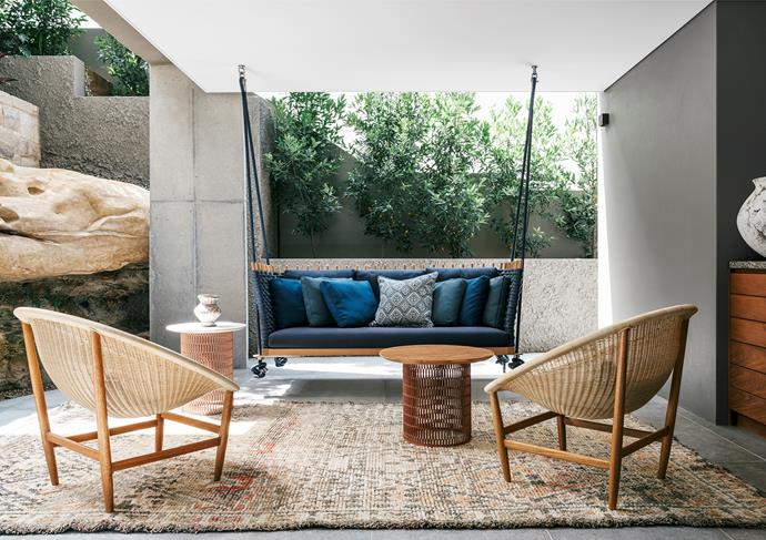 An intimate setting off the lower-ground floor, sheltered by the sandstone cliff. Paola Lenti 'Wabi' swing seat, Dedece. Kettal chairs and tables. Walter G cushions, Ascraft. Vase, Water Tiger. Rug, Cadrys.
