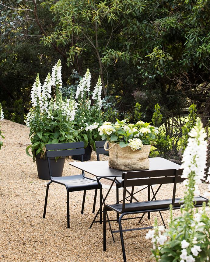 A sunny area outside the guest cottage with crunchy-gravel charm. Table and chairs, Cafe Culture+Insitu. Pots and foxglove plants from Julian Ronchi Garden Design & Nursery.