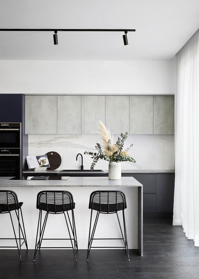 This contemporary space mixes materials to great effect. A [marble splashback](https://www.homestolove.com.au/statement-kitchen-splashbacks-4432|target="_blank") adds elegance to the industrial grey concrete, and delicate porcelain finishes are grounded by the timber flooring. From the sink to the stools, the neutral colour palette proves sophistication need not be subtle. 

*Photographer: Tess Kelly*