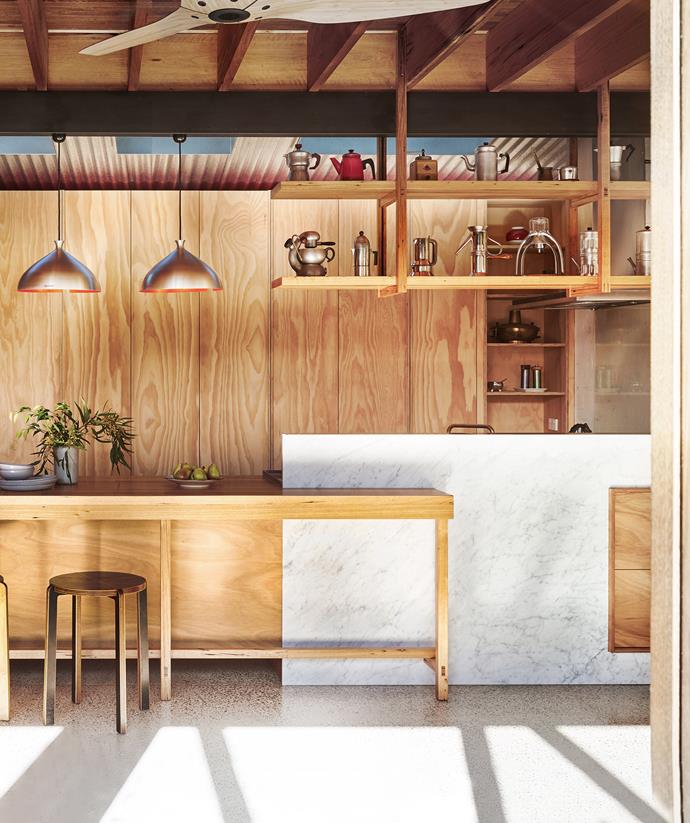Sincere Japanese design meets [Scandinavian minimalism](https://www.homestolove.com.au/scandi-style-minimalist-kitchens-4902|target="_blank") in this [timber kitchen](https://www.homestolove.com.au/15-timeless-timber-kitchens-4678|target="_blank"). Made with seamless hidden doors, the wall cupboards and parallel shelving are beautifully austere, while the bronze pendants and warmth of the natural woodgrain restore balance. 

*Photographer: Nikole Ramsay*