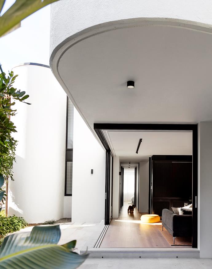 Decus Interiors took cues from [this Sydney home's beachside location](https://www.homestolove.com.au/an-architectural-marvel-by-the-sea-2700|target="_blank") to deliver a laid-back, shoes-off mindset. Walls of sliding glass connect the media room with the garden.