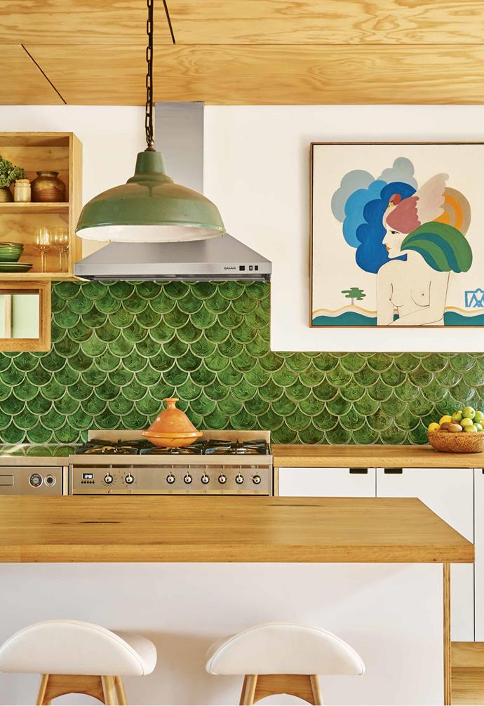 **Be bold** The dramatic green fish scale tiles in this [coastal home](https://www.homestolove.com.au/second-life-a-coastal-home-filled-with-vintage-finds-18573|target="_blank") makes a vibrant statement. Timber benchtops mirro the timber-lined ceiling and flooring, and white walls and white cabinetry break up the palette. <br><br>*Styling: Emma O'Meara | Photography: Nikole Ramsay*