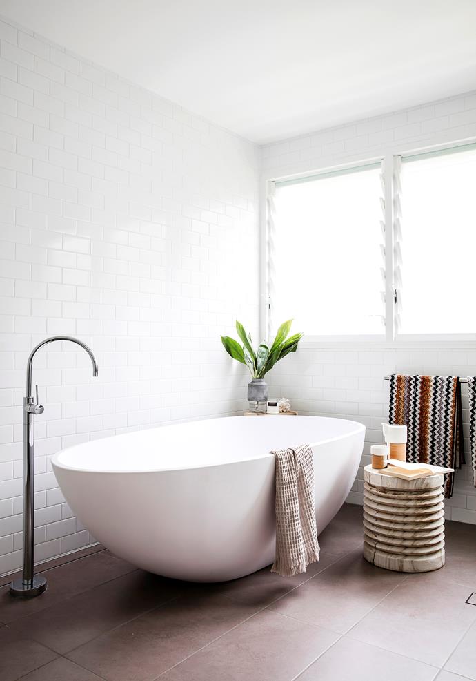 Rachel created the white bathroom using Tiles By Kate subway tiles with Caesarstone benchtops and a freestanding Luna 1680 stone bath from Bathroom Warehouse.