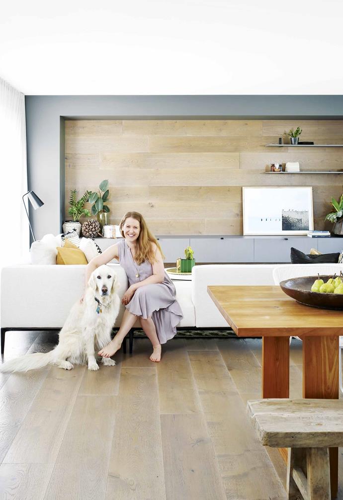 **Living area** Homeowner Megan Fenner with her dog Henry. Interior designer Luisa Klinge of Arki Haus came up with a series of clever timber wall panels for the TV cabinetry, to hide all the cords and cables. Artwork by [Alanna Jayne McTiernan + Co](http://www.alannajaynemctiernan.com/|target="_blank"|rel="nofollow").