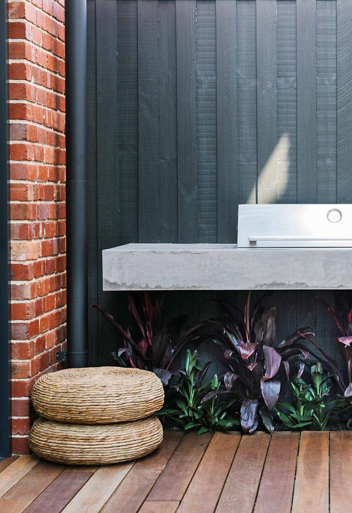 **Deck** An [outdoor kitchen](https://www.homestolove.com.au/outdoor-kitchen-ideas-6227|target="_blank") with a [BeefEater](https://www.beefeaterbbq.com.au/|target="_blank"|rel="nofollow") barbecue creates a walkway between the house and the studio apartment. The palette of concrete, red brick and black wood continues inside.