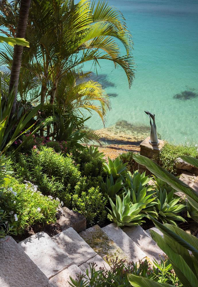 ** Matthew Cantwell - Secret Gardens** <p>
Stone steps lead to the waterside deck equipped with a cooking area. Bronze sculpture with golden cane palms, agaves, dwarf oleander and *Rhaphiolepis* 'Snow Maiden.' *Photograph*: Nicholas Watt