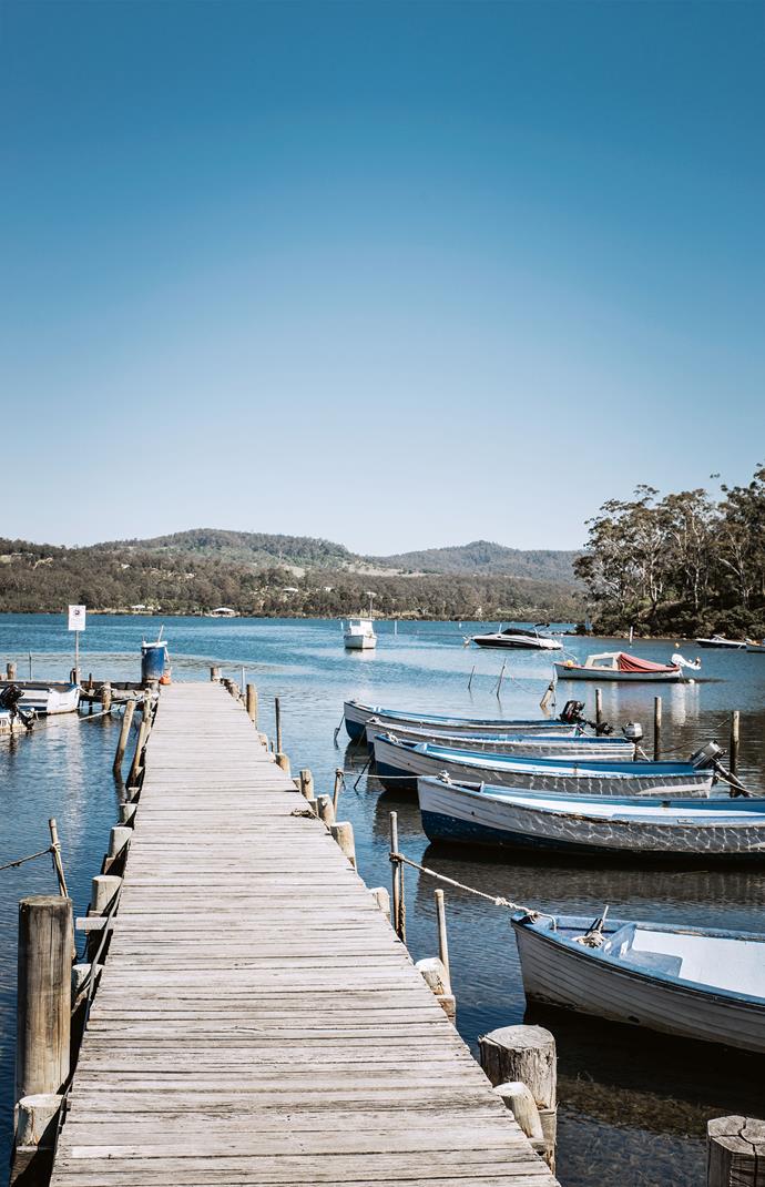 A jetty with boats for hire juts out from the boardwalk at Merimbula.